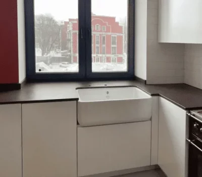 Столешница из керамогранита сложной формы для кухни в сталинке: бесшовная поверхность, вырез под раковину и плиту, матовая текстура, идеально вписана в интерьер старого дома.